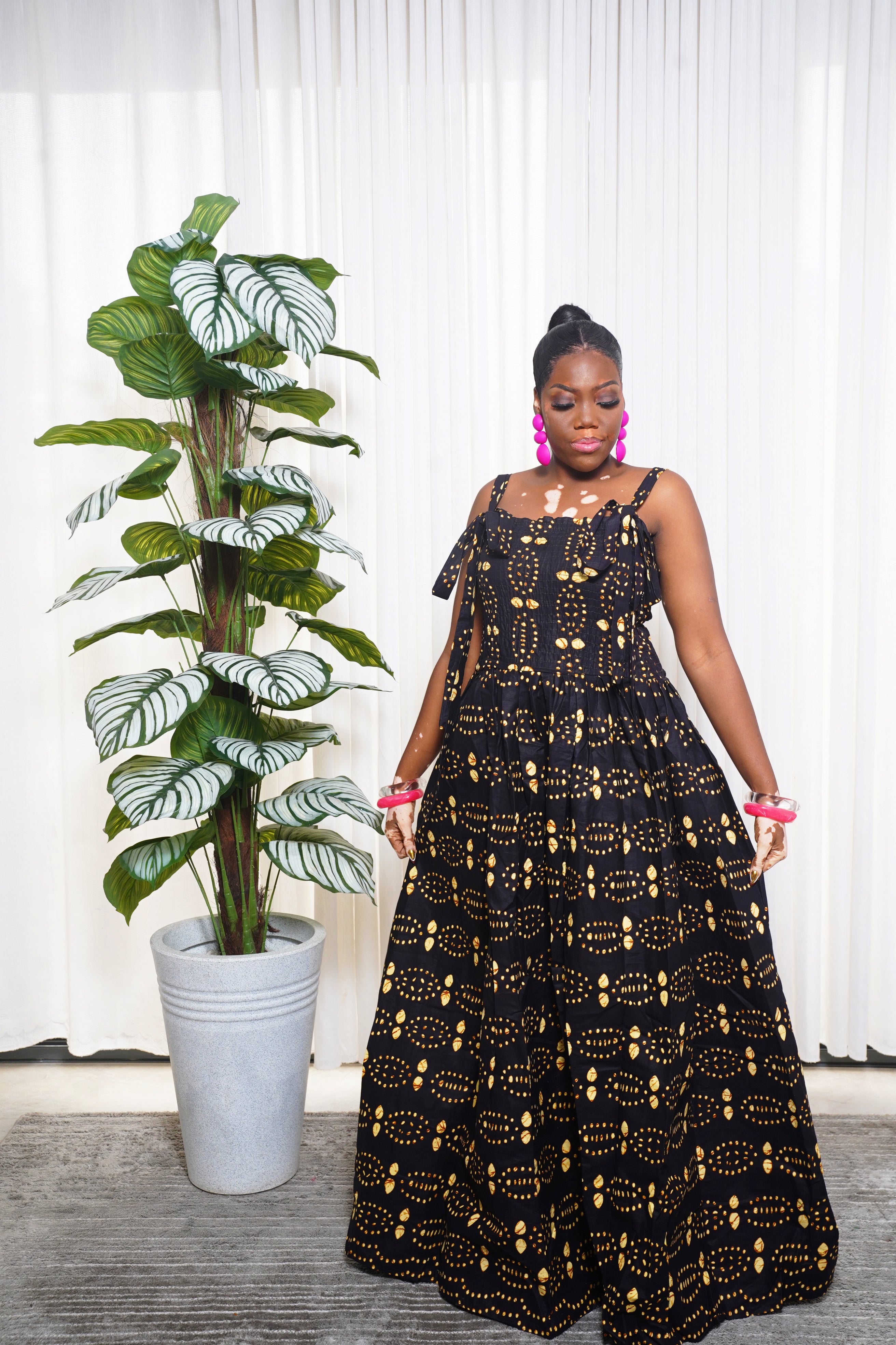 Woman wearing black and gold patterned Ankara maxi dress by Selaro Luxury Wears
