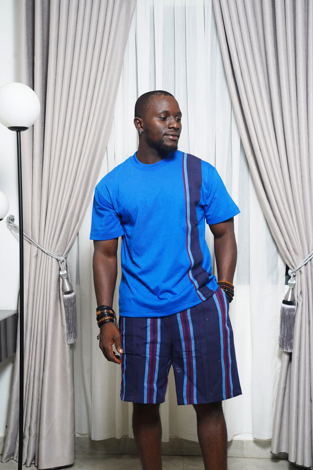 Bright blue shirt with purple stripe panel styled with matching striped shorts and bracelets