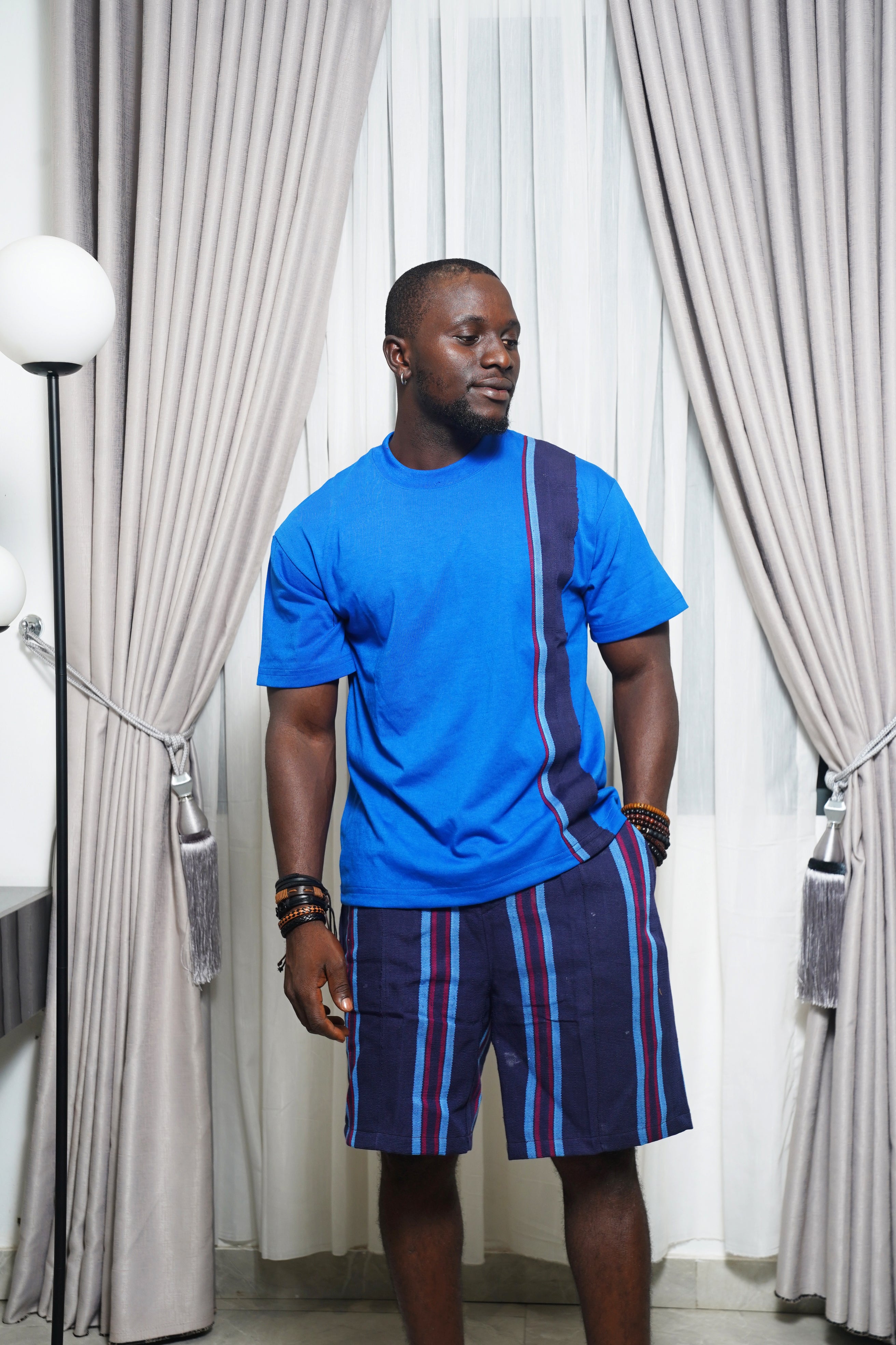 Bright blue shirt with purple stripe panel styled with matching striped shorts and bracelets