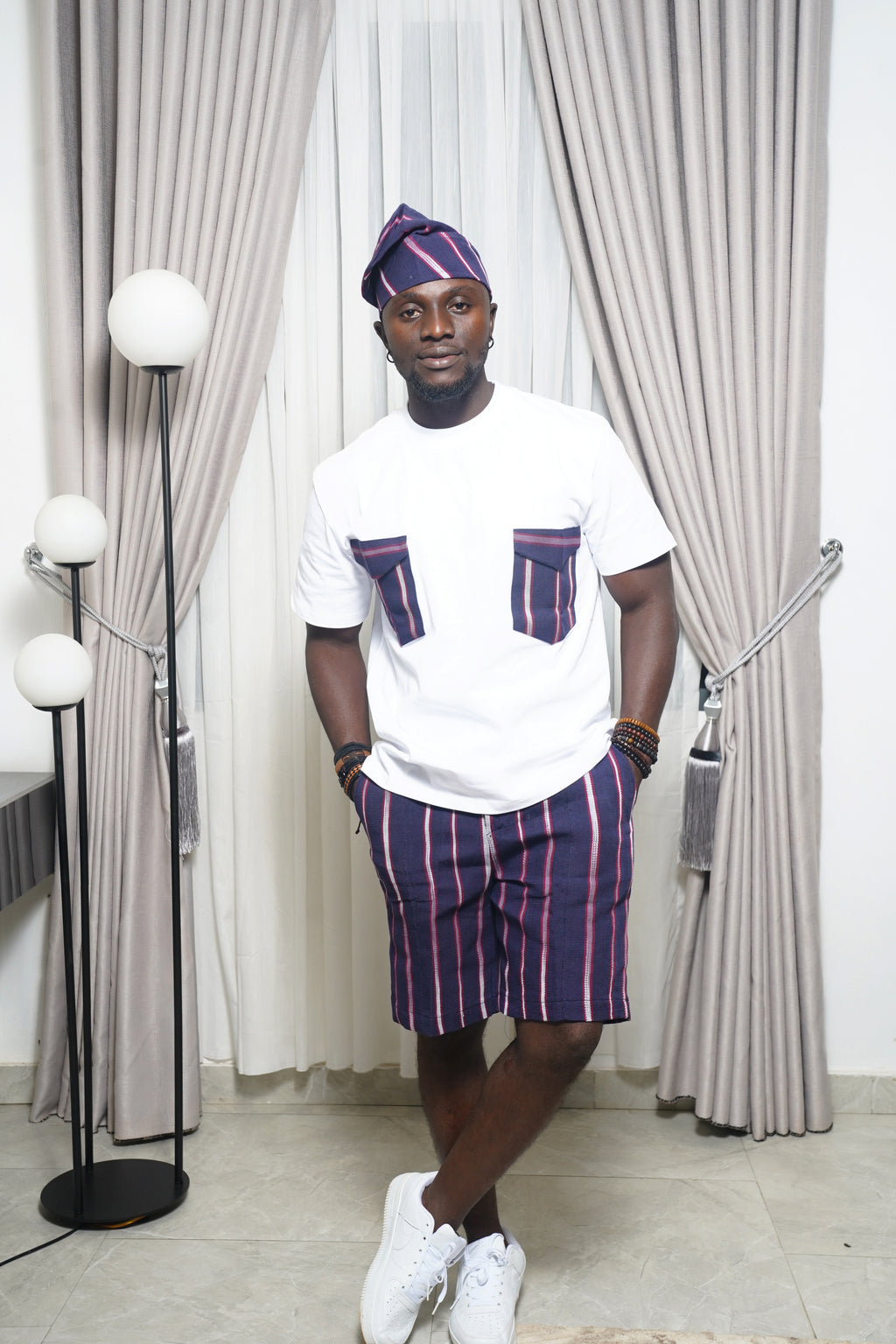 Blue short‑sleeve shirt with vertical stripe detail paired with blue and purple striped shorts