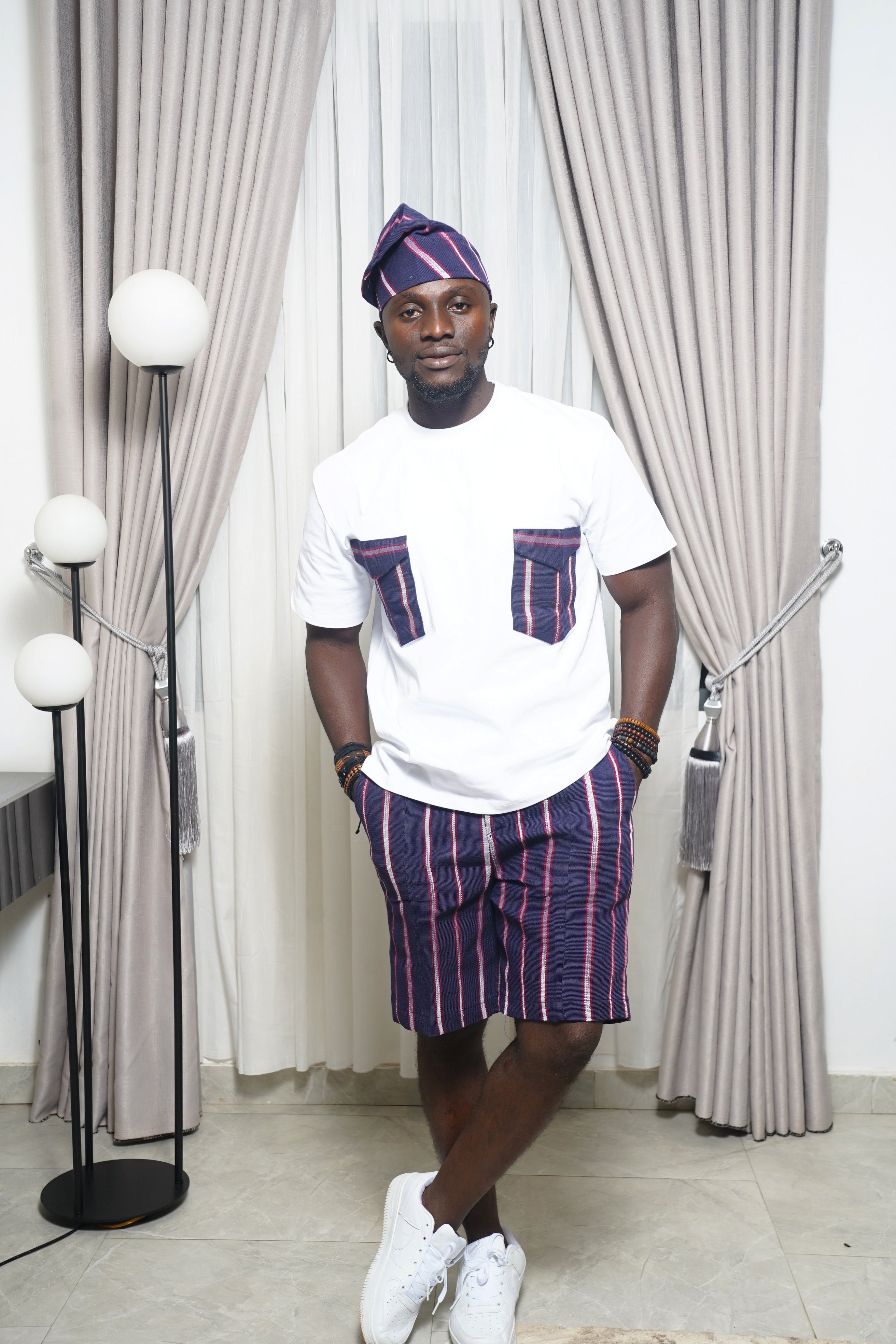 Blue short‑sleeve shirt with vertical stripe detail paired with blue and purple striped shorts
